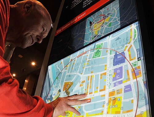 man using Legible Leeds wayfinding totem at night.