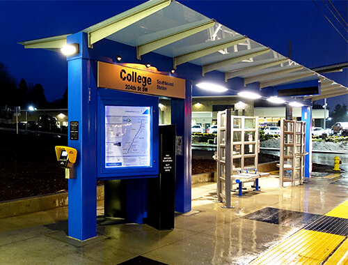 waiting shelter with a covered canopy over ticket machine.