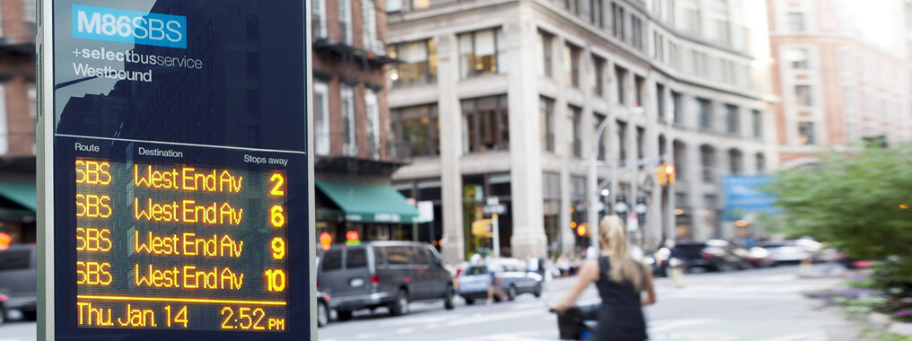 Outdoor digital totem with real-time passenger information being displayed.
