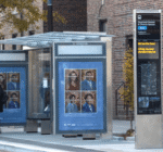 Double sided LED SBS wayfinding totem in with real-time passenger information next to a bus stop.
