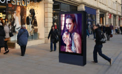 Double sided 75" Digital 6 sheet outdoor display on a side walk next to a retail shop.